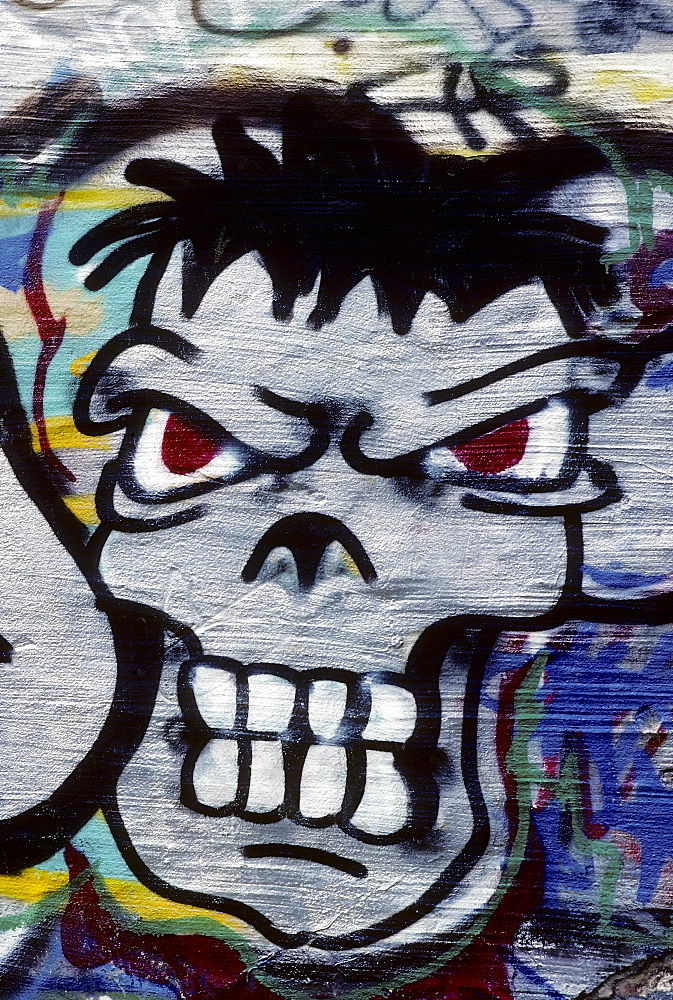 Grim face, looking aggressive with bared teeth, graffiti