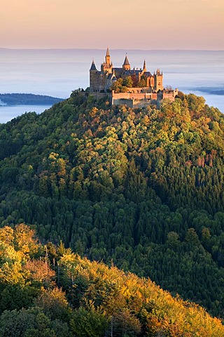 Hohenzollern Castle in the morning light with autumn forests, early morning fog, Swabian Alb, Baden-Wuerttemberg, Germany, Europe