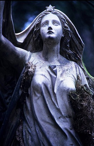 Weathered statue of a woman in a cemetery