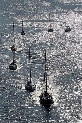 Sailing boats and motorboats in back light