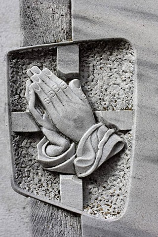 Praying hands on a tombstone