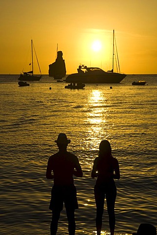 Couple watching sunset at Cala Benirras, Ibiza, Spain, Europe