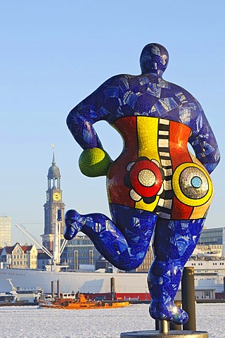 Nana sculpture in front of the tent of the musical The Lion King in the Hamburg harbor, rear view, in the back the St. Michaelis church, Landungsbruecken jetties, Hamburg, Germany, Europe