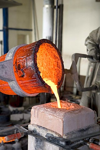 Liquid bronze at 1250âˆž C is being poured into a mold in an art bronze foundry