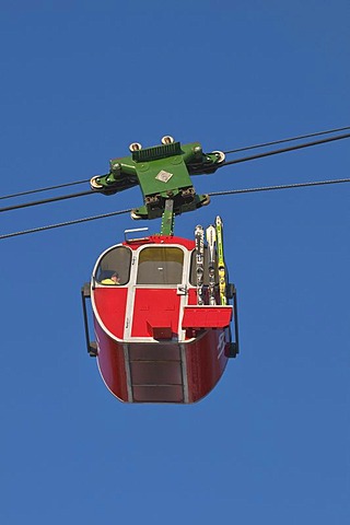 Red cabin of the Kampenwandbahn ropeway with skis on the outside of the cabin, ascend to the mountain, Chiemgau, Bavaria, Germany, Europe