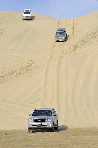 Three off-roaders driving in sand dunes, Emirate of Qatar, Persian Gulf, Middle East, Asia