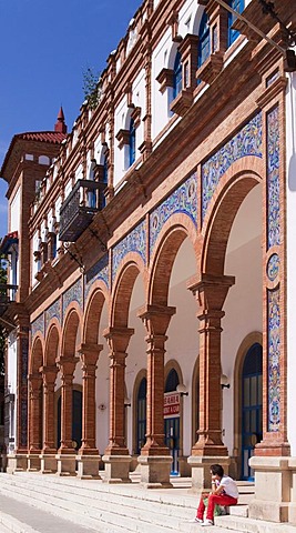 Man sitting on the steps of the entrance to the station in Jerez de la Frontera, Spain, Europe
