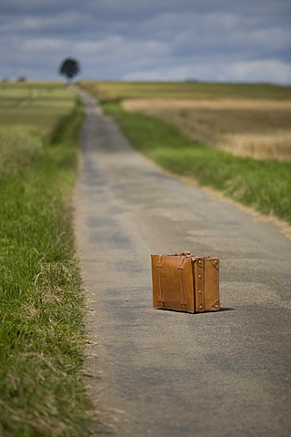 Suitcase, country road, symbolic image Last trip, death