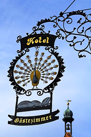 Elaborate advertising sign "Hotel Pfauen" hotel peacock, in the back an old gate tower, Hauptstr. 78, Endingen am Kaiserstuhl, Baden-Wuerttemberg, Germany, Europe