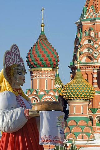 Russian doll in front of the towers of the orthodox Saint Basil's Cathedral, Moscow, Russia