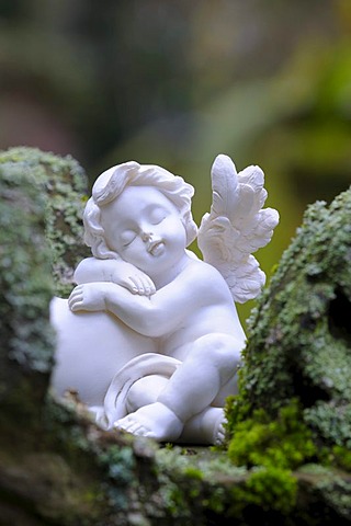 Angel figurine made of clay on mossy stones