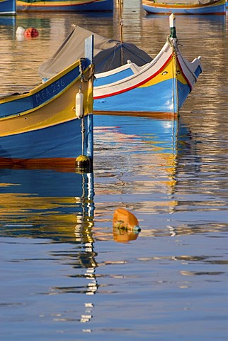 Luzzus, the typical colorful fishing boats of Malta, in Marsaxlokk Harbour, Malta, Europe