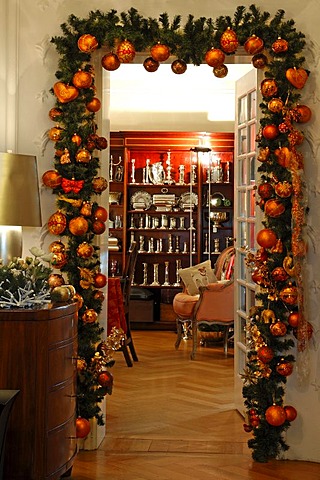 Doorway decorated with pine branches and Christmas baubles, view to a display cabinet with silverware, Villa & Ambiente store, Im Weller, Nuremberg, Middle Franconia, Bavaria, Germany, Europe