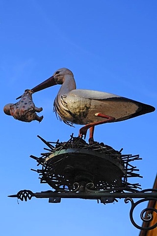 Stork with baby figure in its beak above a children's shop, Obere Bruecke, Bamberg, Upper Franconia, Bavaria, Germany, Europe