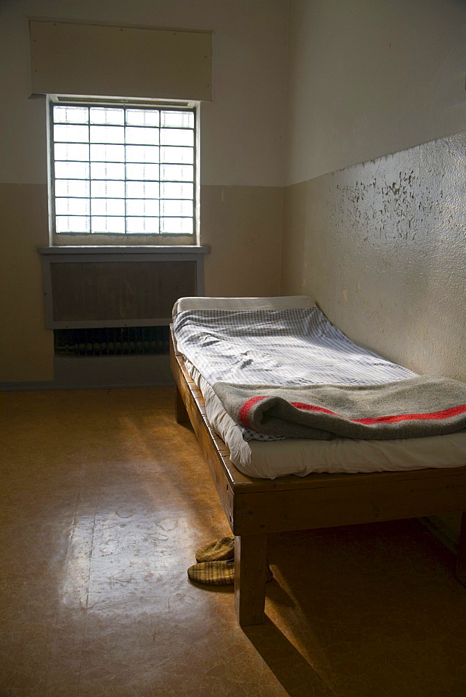 Cot with original bed covers, blanket and slippers in a cell, Berlin-Hohenschoenhausen memorial, former prison of the GDR's secret service, Berlin, Germany, Europe