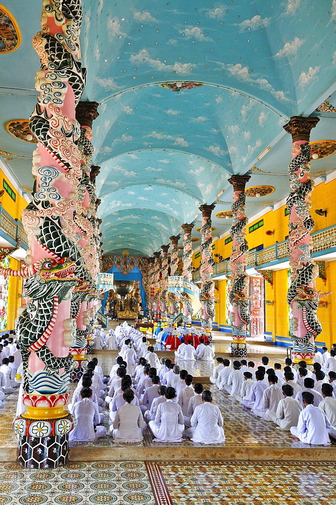 Praying devout men and women, ceremonial midday prayer in the Cao Dai temple, Tay Ninh, Vietnam, Asia