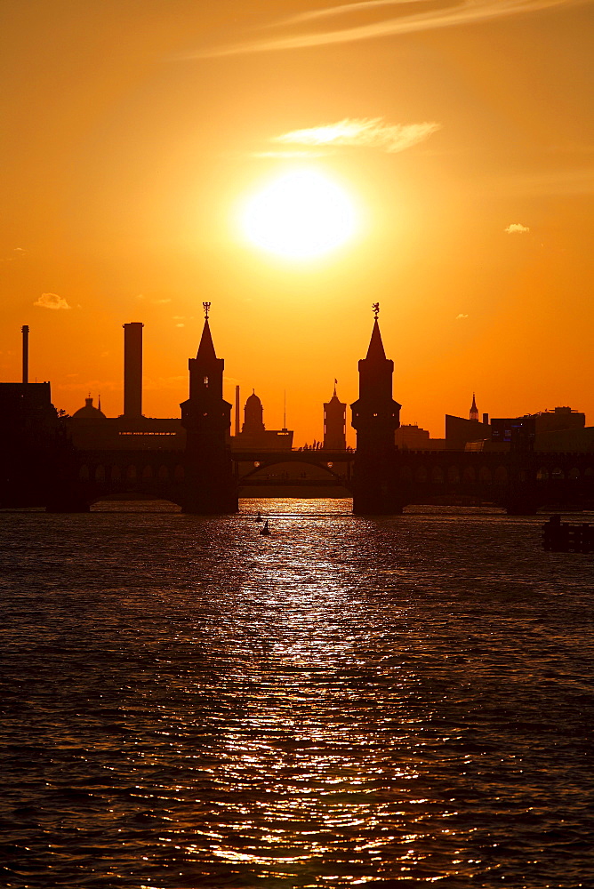 Silhouette of the Oberbaumbruecke bridge across the Spree river and Rotes Rathaus town hall at sunset in Berlin, Germany, Europe