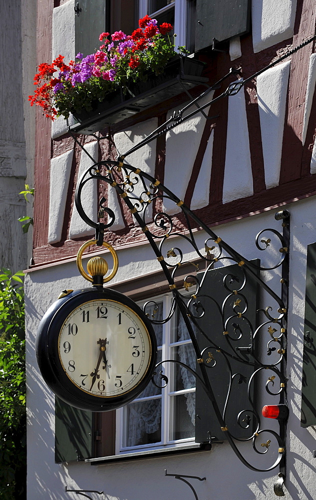 Clock in the form of a pocket watch on a half-timbered house, Biberach an der Riss, Baden-Wuerttemberg, Germany, Europe