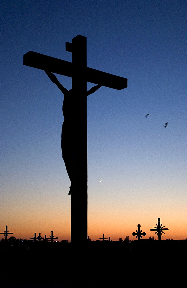 Silhouette of the monument to visit of Pope John Paul II on 07.09.1993 against the evening twilight on the Hill of Crosses, Siauliai, Lithuania, Europe