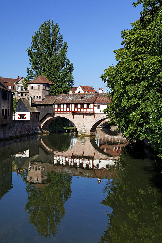 Executioner's home with half-timbered building, bridge building with two arches, small fortified tower and high water tower, Pegnitz river, trees, reflection, old town, Nuremberg, Middle Franconia, Franconia, Bavaria, Germany, Europe