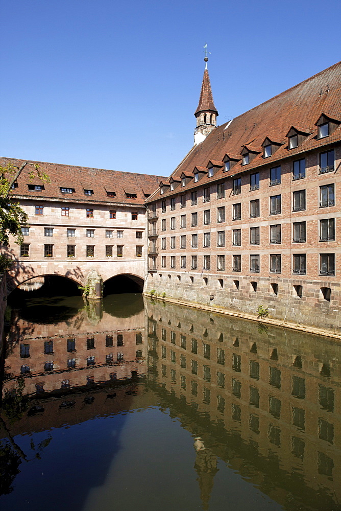 Public historic Heilig-Geist-Spital Holy Spirit hospital, retirement home, church tower, courtyard, arcades, reflection, old town, Nuremberg, Middle Franconia, Franconia, Bavaria, Germany, Europe