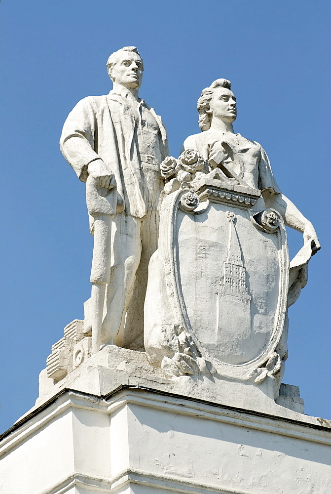 Figures of the Soviet engineers on top of the building on the territory of the VVTs or VDNKh, All Russian Exhibition Centre, Moscow, Russia