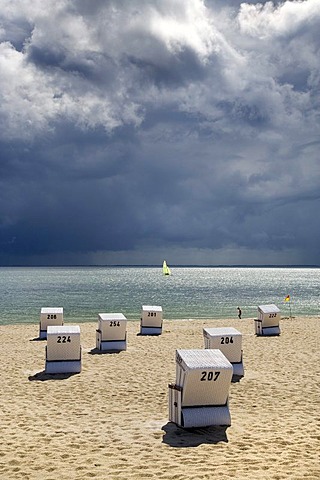 Beach with roofed wicker beach chairs in front of dark clouds, impending thunderstorm, Hoernum, Sylt, North Frisia, Schleswig-Holstein, Germany, Europe