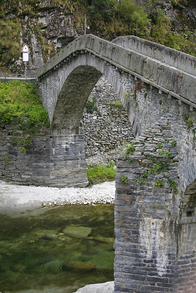 The ancient stone bridge of St. Roch, in the shape of a donkey's back across the river Merla, Bignasco, Val Lavizzara, Maggia valley, Ticino, Switzerland, Europe