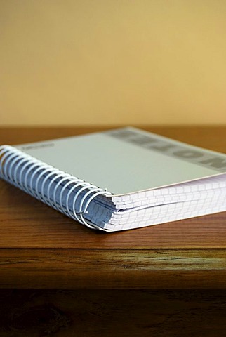 Closed ringed notebook, notebook on a wooden desk