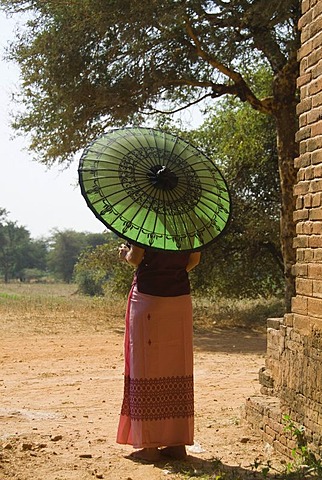 Back view of a young Burmese woman with a green parasol, Bagan, Myanmar