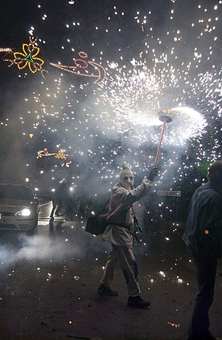 During the Correfoc or Fire Run, hooded Fire Devils run through the streets of Spanish towns brandishing fireworks, Altea, Costa Blanca, Spain, Europe