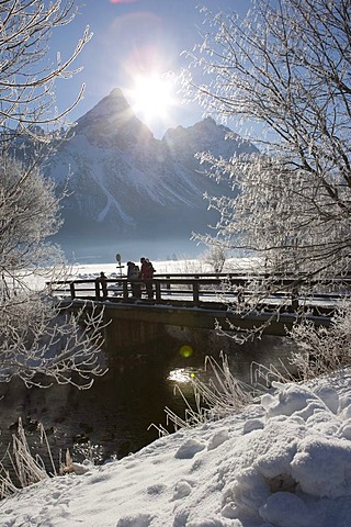 Hikers standing on a snow-covered bridge in front of Sonnenspitze mountain, Tyrol, Austria, Europe