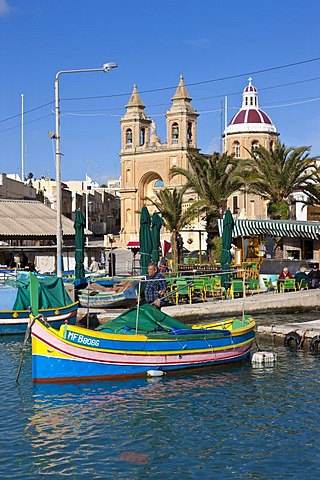 Traditional Maltese fishing boat, called Luzzu, in front of the Church of Our Lady of Pompeii, port of Marsaxlokk, Malta, Europe