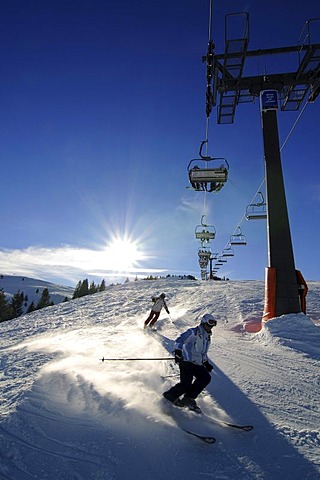 Skier skiing in powder beneath the Kitzlahner-Bahn ski lift, Sudelfeld ski area, Bayrische Alpen or Bavarian Alps, Bavaria, Germany, Europe