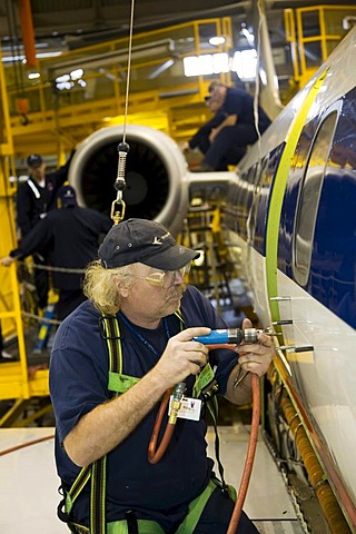 Worker does heavy maintenance on Embraer aircraft flown by American Eagle, Gwinn, Michigan, USA