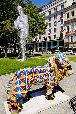 The lion the symbol for the Freistaat Bavaria on the Promenadenplatz, in the background the statue sculpture Montgelas, lion parade in Fuenf Hoefe Munic Bavaria Germany