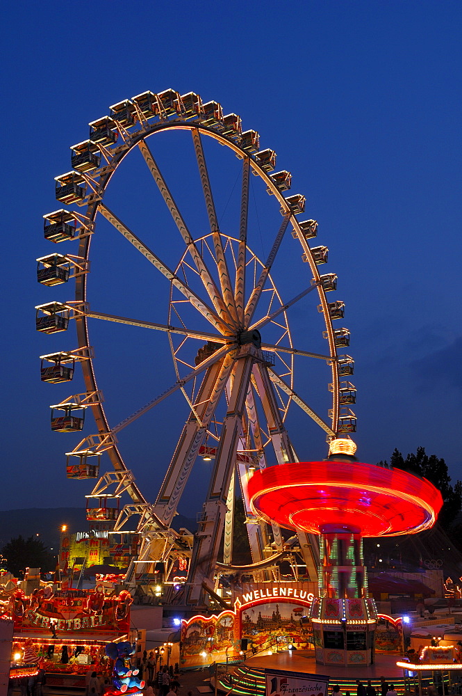 Ferris wheel and swing carousel at a fair in Stuttgart, Baden-Wuerttemberg, Germany, Europe