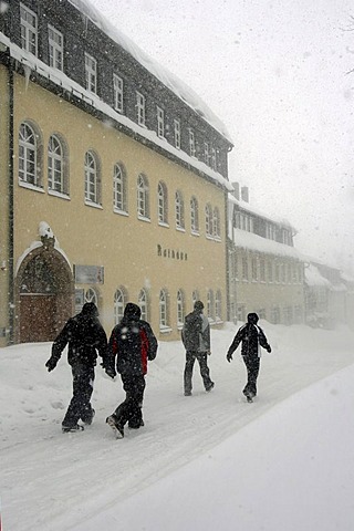 Pedestrians walk through the snow passing the town hall in Oberwiesenthal, Erzgebirge, Erz Ore Mountains, Saxony, Germany