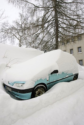 Snowed in car on a snow covered parking lot in Oberwiesenthal, Erzgebirge, Erz Ore Mountains, Saxony, Germany