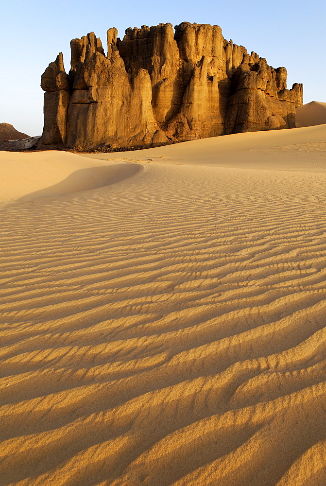 Eroded rock formations rising out of desert sand dunes, ripples in Tin Akachaker, Tassili du Hoggar, Wilaya Tamanrasset, Sahara Desert, Algeria, North Africa