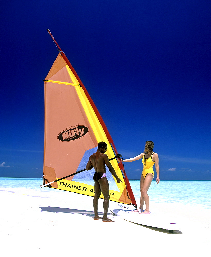 Young woman with a windsurf board, windsurfing lessons, Maldives, Indian Ocean