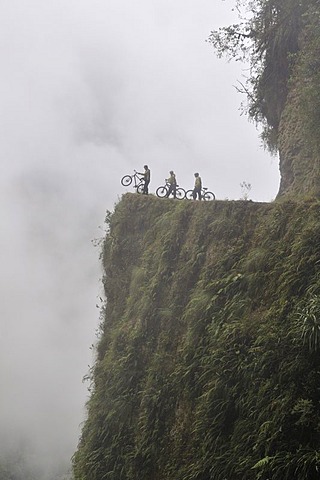 Mountainbikers at the edge of a dangerous cliff, Deathroad, Yungas, La Paz, Bolivia, South America