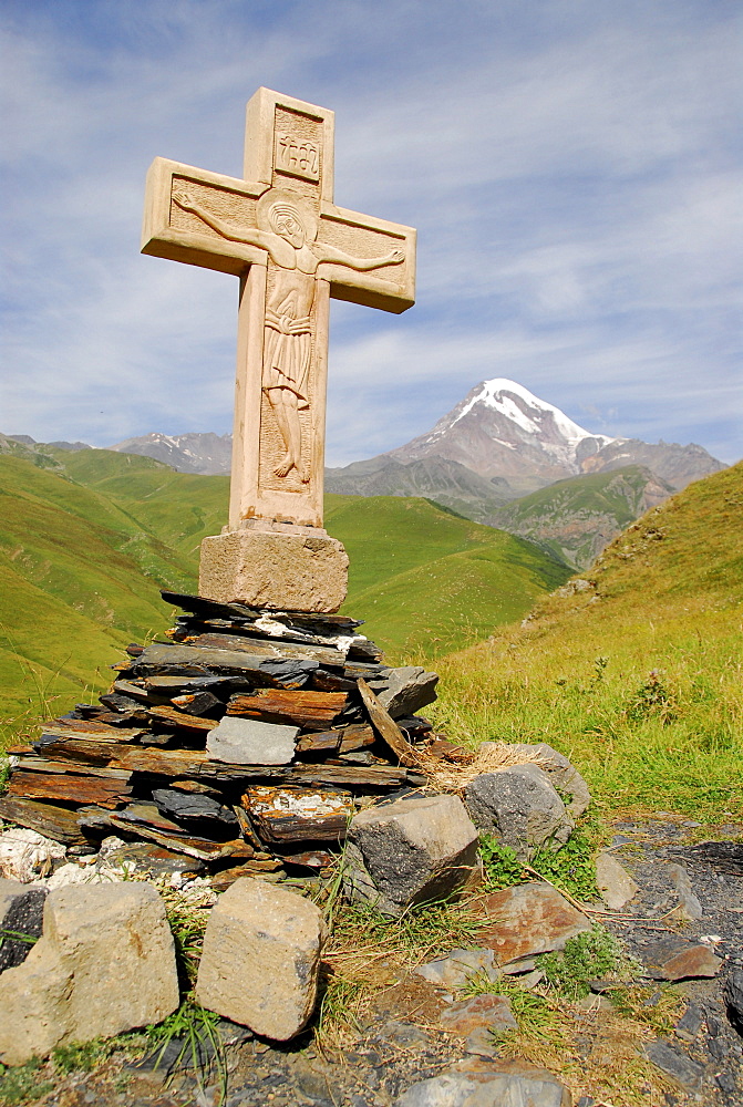 Cross at Gergeti Church in front of 5047 meters high Kasbeg peak, Kasbegi, Georgia