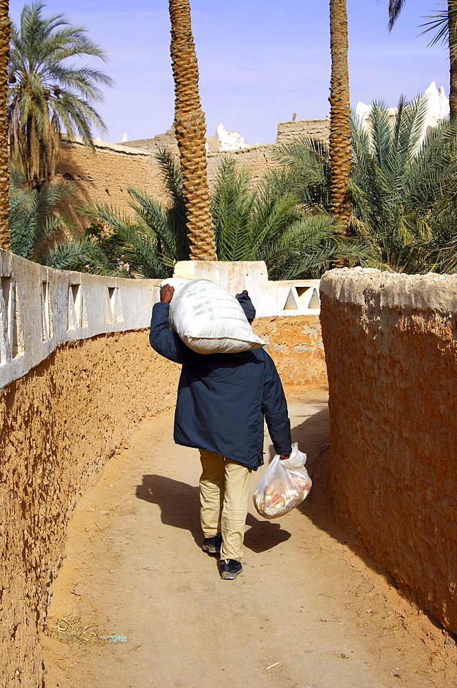 Man returning from the market with heavy bags, Old town of Ghadames Libya