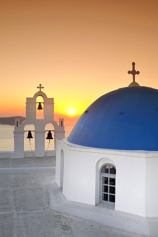 White Greek church with a blue dome and a bell tower at sunset, Firostefani, Santorini, Cyclades, Greece, Europe