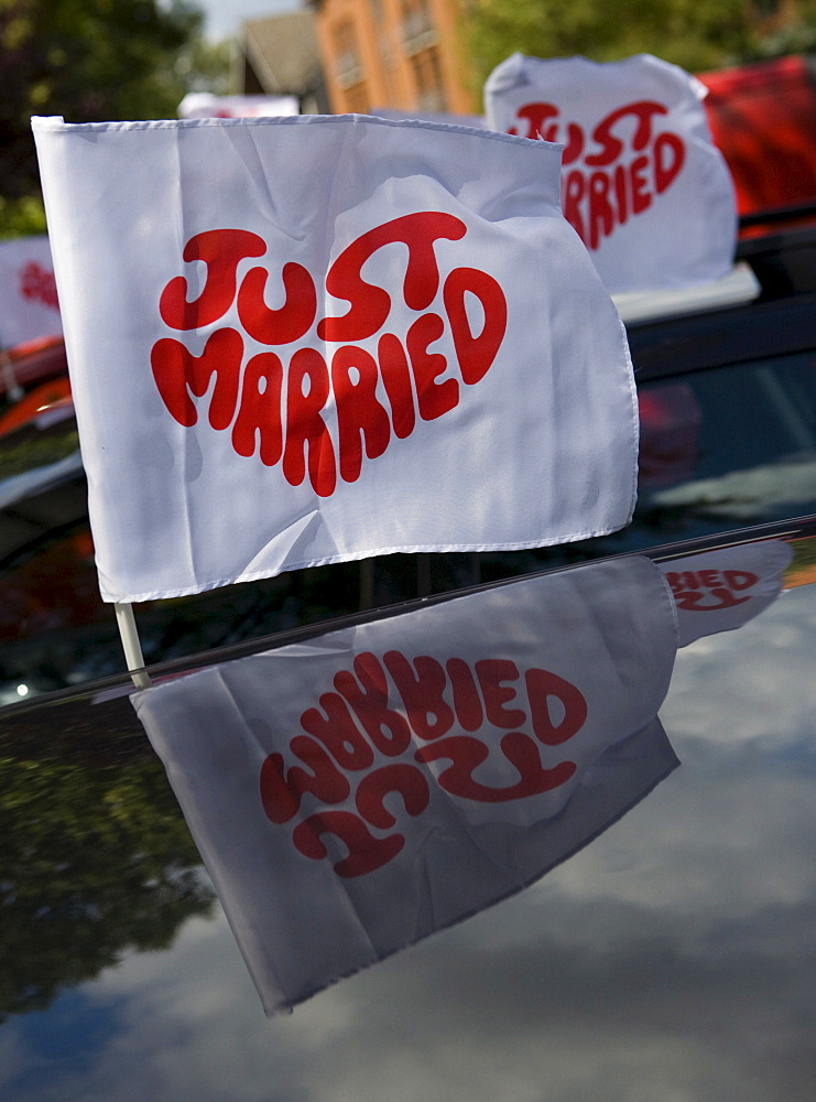 Ensign with writing "just married" reflecting in the car roof