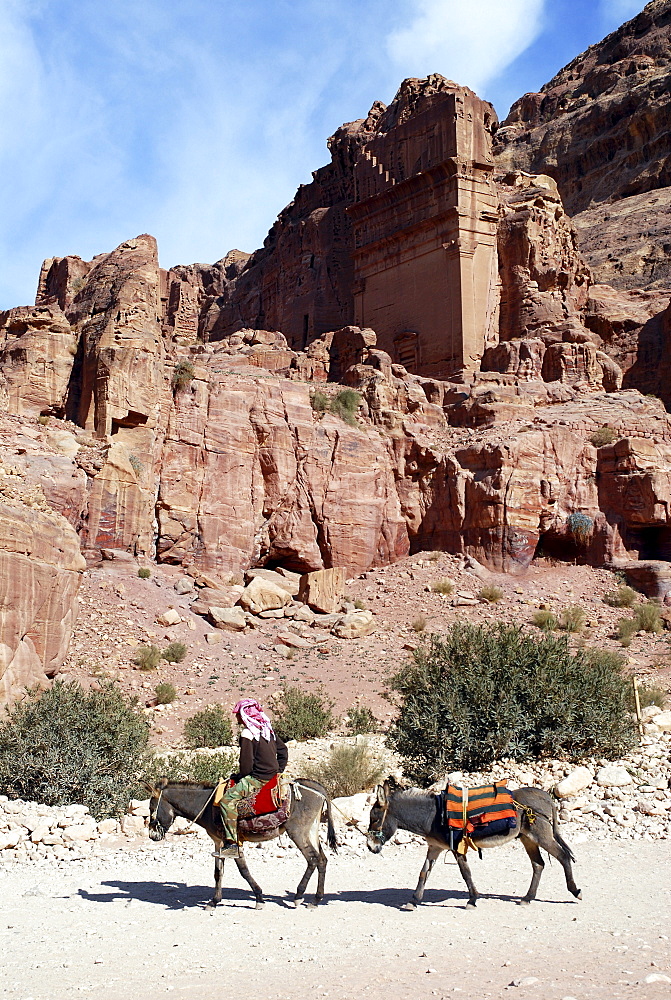 Bedouin riding a donkey or ass (Equus asinus) in the ancient Nabataean rock city of Petra, Jordan, Middle East, Asia