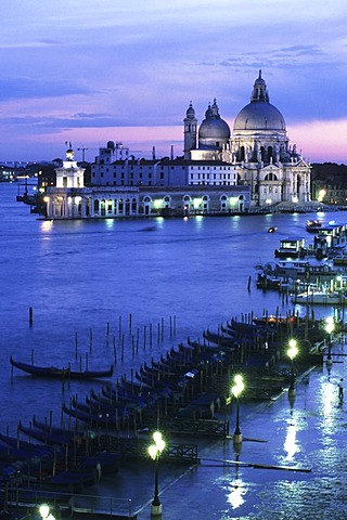 ITA; Italy, Venice : Gondolas at the Sestiere die San Marco, at night. Behind Basilika S. Maria della Salute |