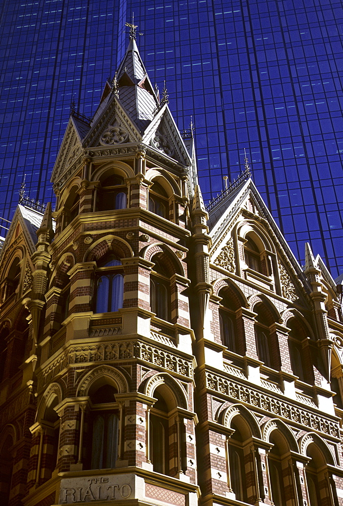 The Rialto Hotel in front of the glass facade of the Rialto Towers in Melbourne, Victoria, Australia