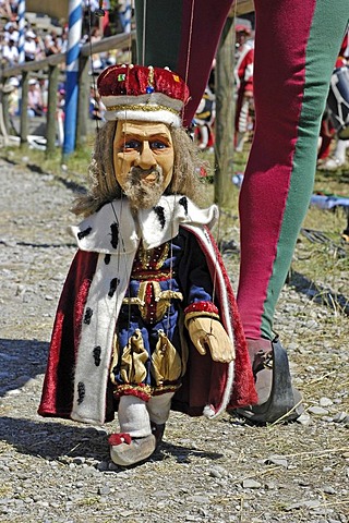 Puppet player in mediaeval medieval costume holding little marionette king , knight festival Kaltenberger Ritterspiele, Kaltenberg, Upper Bavaria, Germany